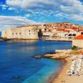 Aerial view of Dubrovnik, surrounded by water and filled with terracotta-roofed buildings