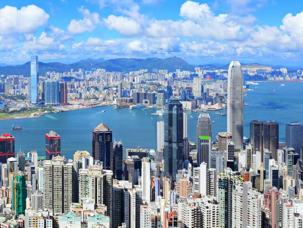 Train riding in front of the cityscape of Hong Kong