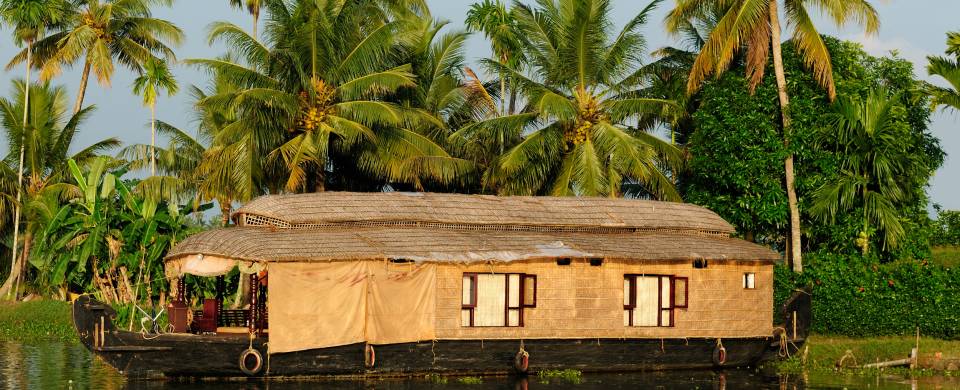 Wooden boat drifting along the river in Kumarakom