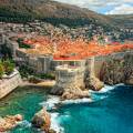 Aerial view of Dubrovnik, surrounded by water and filled with terracotta-roofed buildings