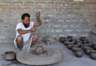 A potter gets to work on his spinning wheel in Bishnoi village